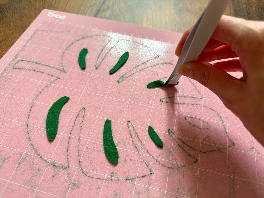 Using Cricut tweezers to remove felt from a Fabric Grip mat