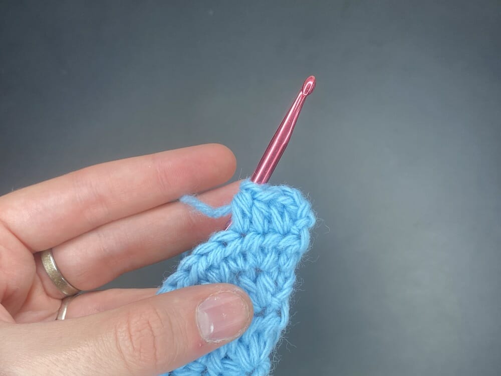 Half double crochet increase into the first stitch of the row, followed by 2 half double crochets (HDC INC, 2 HDC)