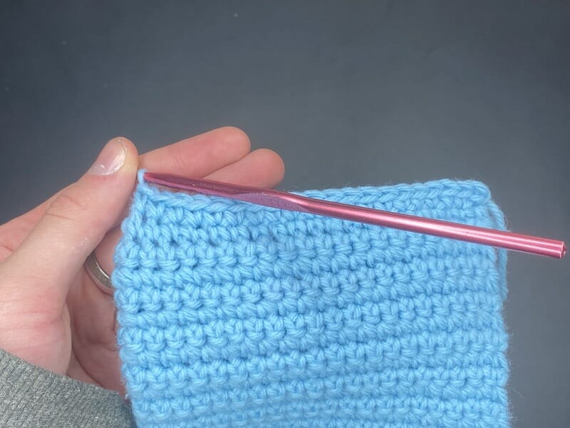 Repeat the step of joining the edges by inserting your hook under both stitches along the edge and single crocheting them together.